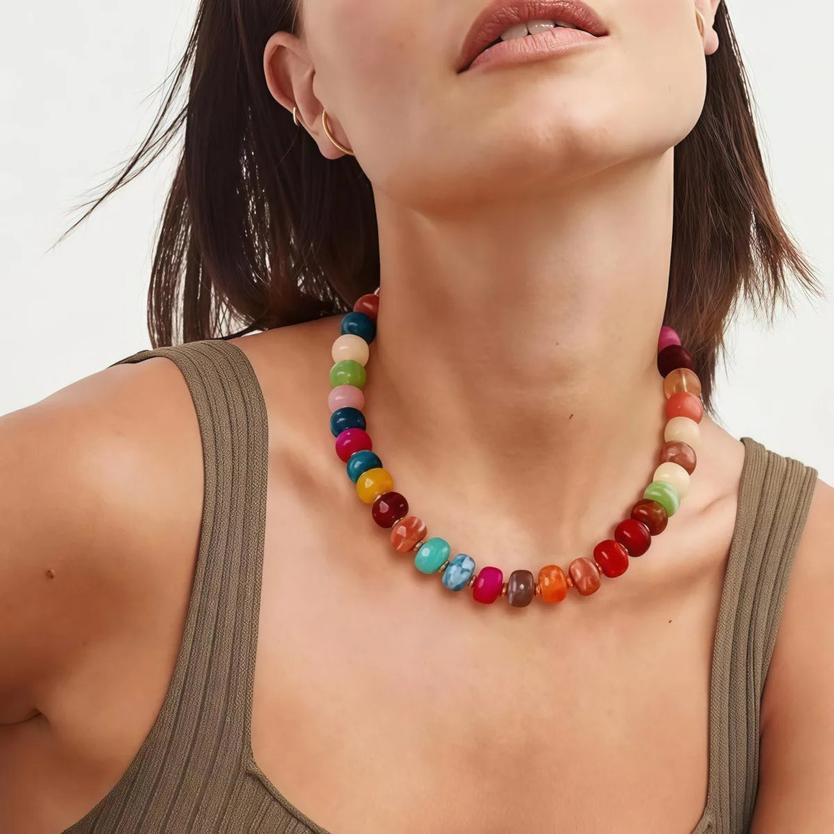 A close-up of a woman wearing a colorful resin beaded statement choker necklace on her neck.
