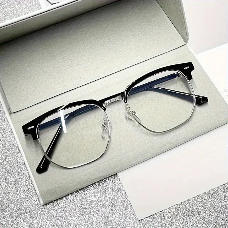 A pair of retro half gold frame anti blue light eyewear resting on a white card inside a gray box.