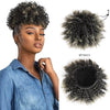 Eine Frau präsentiert eine dunkle lockige Haarverlängerung, einen Afro-Puff-Chignon, vor weißem Hintergrund.