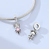 Sterling silver devil's eye charm bracelet featuring a charm of a small figure and a pink gemstone.