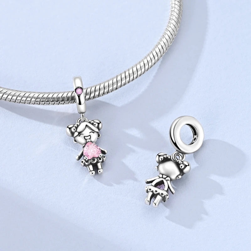 Sterling silver devil's eye charm bracelet featuring a charm of a small figure and a pink gemstone.