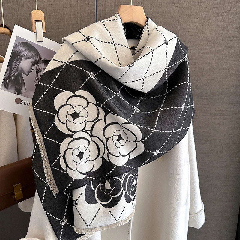 A black and white plaid cashmere feel scarf draped over a white garment.