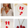 A set of red floral pendant necklace and earring displayed on a white background.