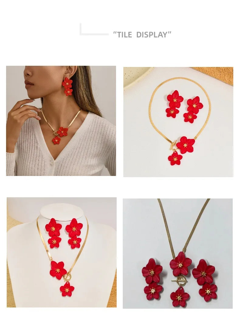 A set of red floral pendant necklace and earring displayed on a white background.