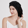 A woman wearing a black Mulberry Silk Sleep Bonnet for Curly Hair