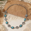 Silver beaded necklace and bracelet set featuring turquoise flower motifs on a natural background.
