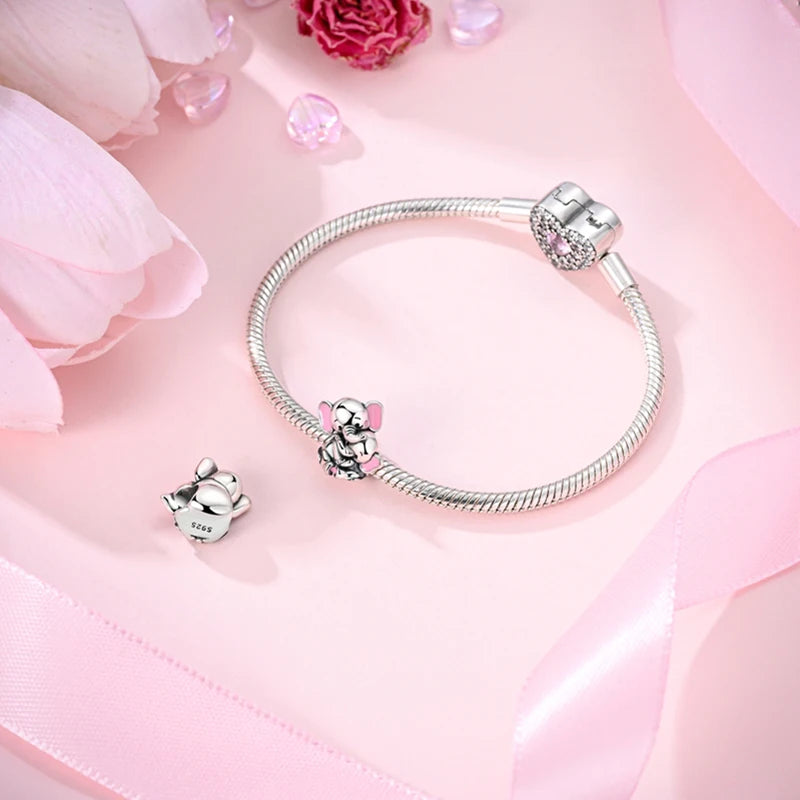 Sterling silver devil's eye charm bracelet displayed on pink fabric with pink flowers.