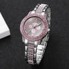 A silver watch with a pink diamond rhinestone bezel and bracelet set against a dark background.