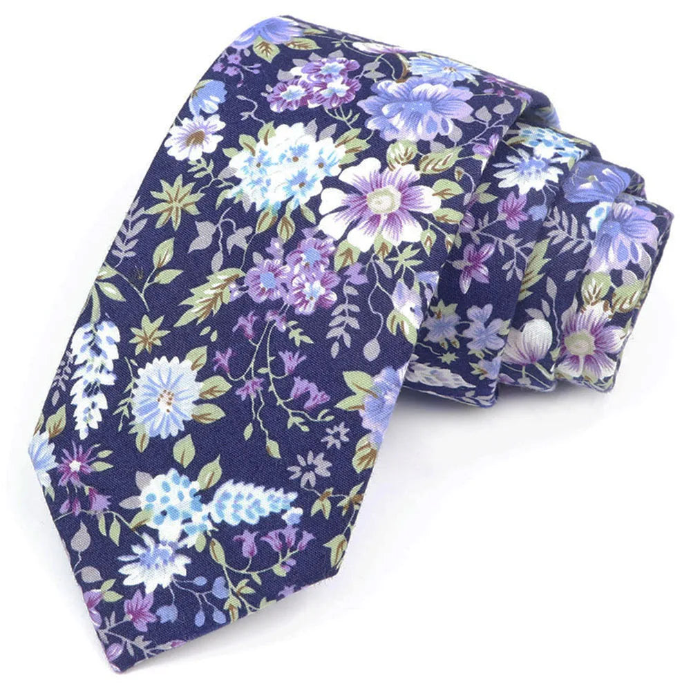 Cravate bleu foncé à motif floral élégant avec des fleurs violettes, blanches et bleu clair et des feuilles vertes.