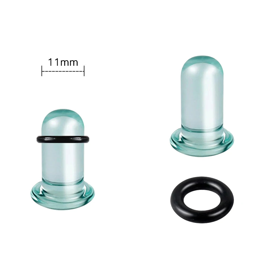 A clear glass ear stretching plug with a black ring and a measuring scale.