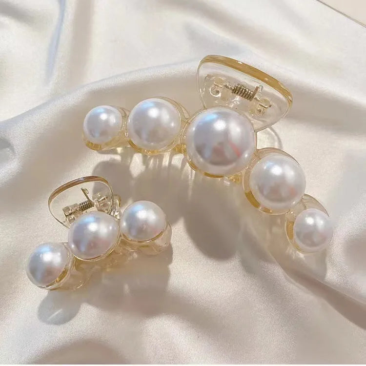 A set of simulated pearl hair claws with clear plastic attachments shown against a white background.