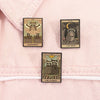 A set of three tarot card enamel pins featuring Judgement, The Moon, and The Lovers on a pink fabric background.