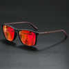 A pair of classic square sunglasses with reddish-orange tinted lenses and dark brown frames resting on a black surface.