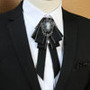 A black tuxedo jacket with a white shirt and a silver rhinestone bow tie neck tie
