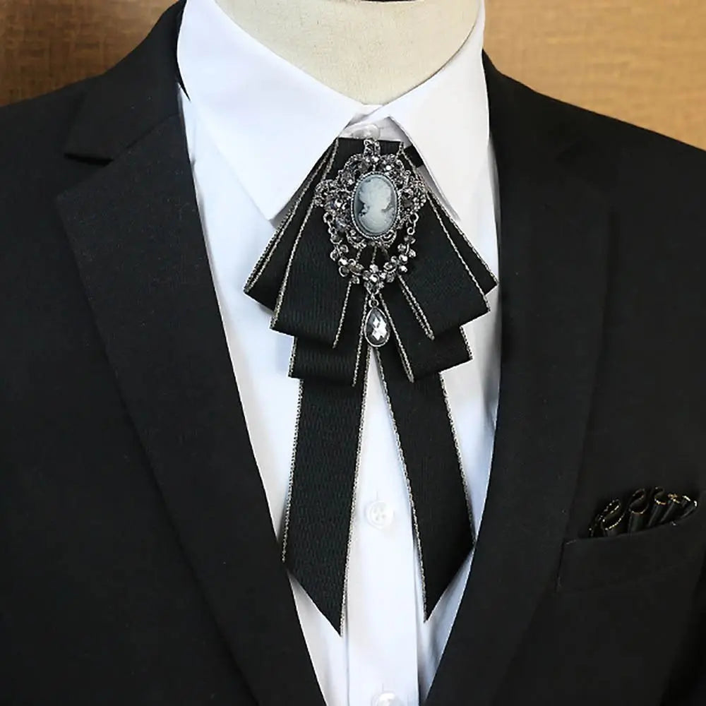 A black tuxedo jacket with a white shirt and a silver rhinestone bow tie neck tie