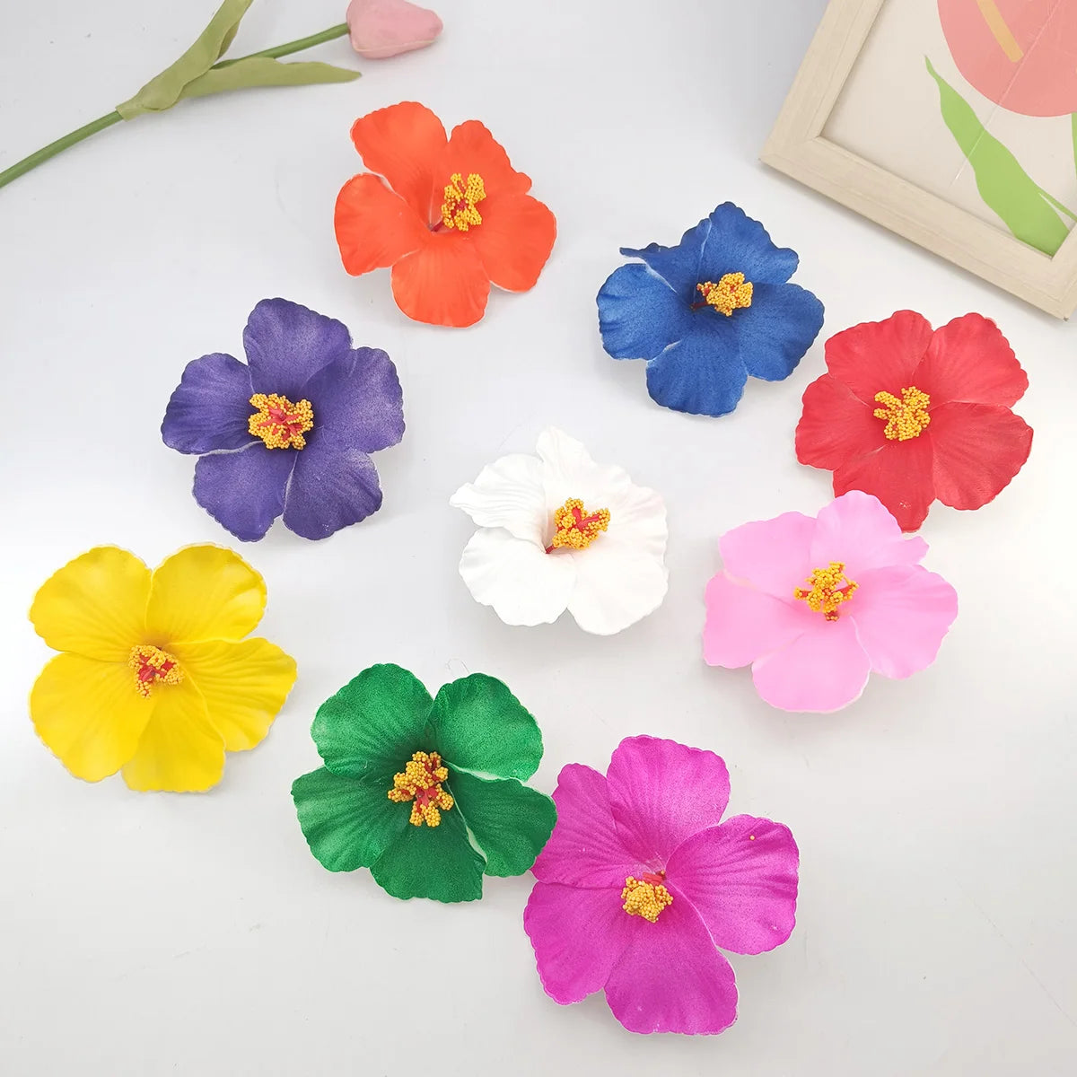 A collection of colorful felt flowers in various shades including orange, blue, purple, red, pink, and yellow.