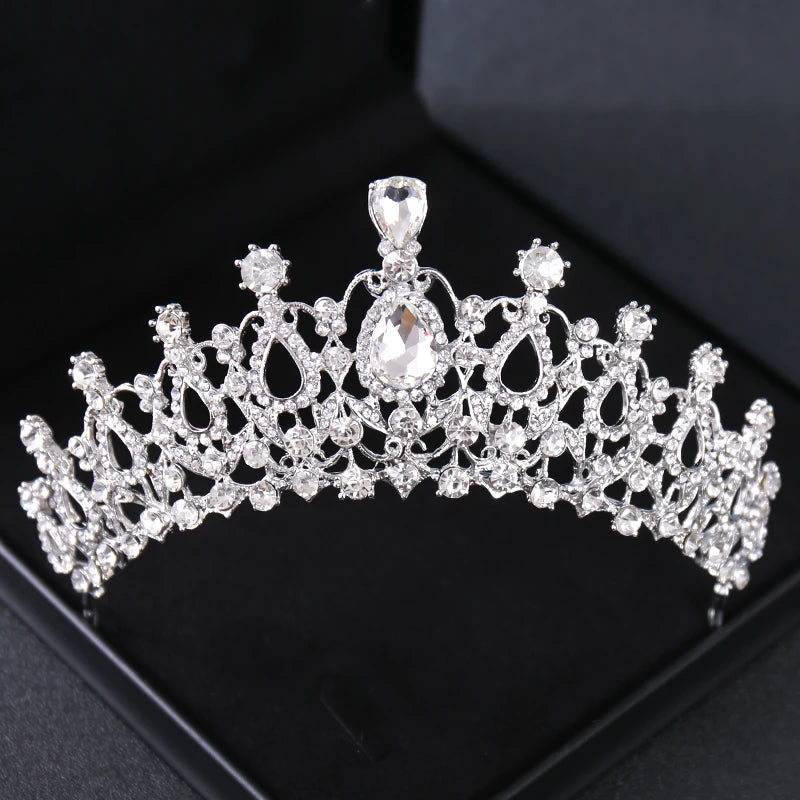 Tiare et couronne en strass de cristal, accessoire de cheveux, sur un fond de velours noir.