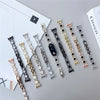 A collection of diamond four-leaf clover watch straps for a Xiaomi Mi Band displayed on a gray surface.