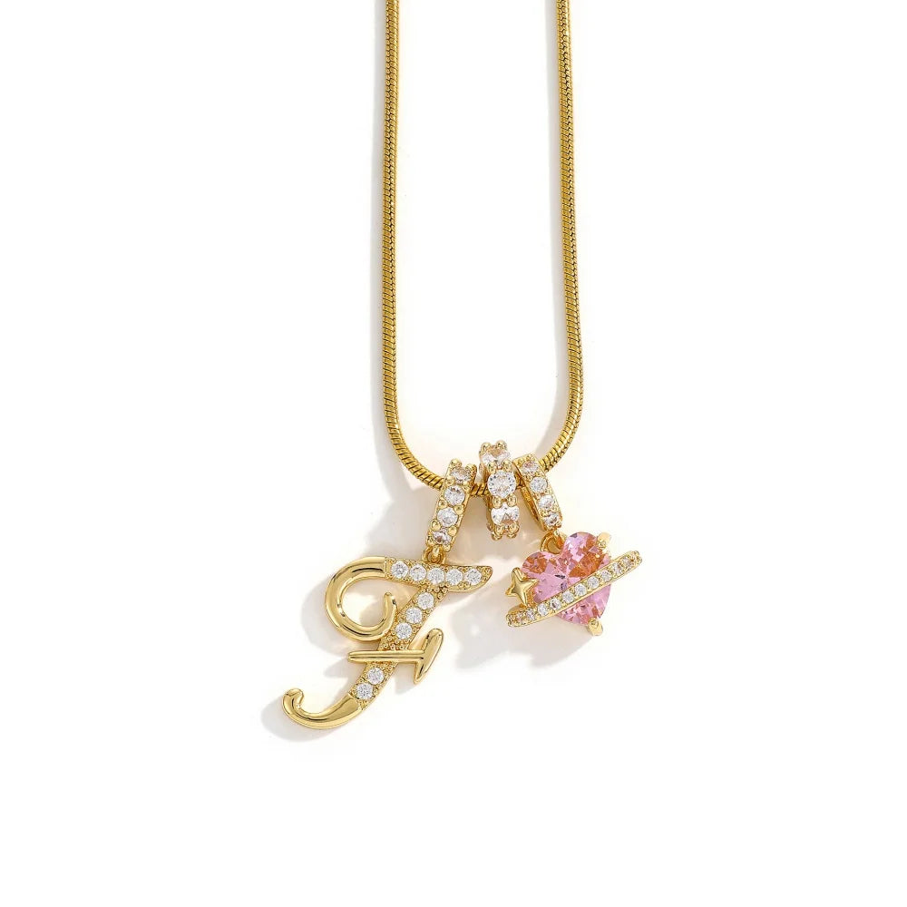 Gold letter M pendant necklace with a pink gemstone flower charm