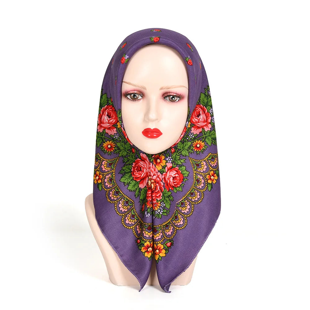 A purple square scarf with a floral print is draped over a mannequin's head.