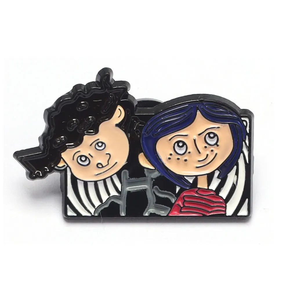 Broche émaillée représentant deux personnages de dessin animé, l'un avec des cheveux noirs bouclés et l'autre avec des cheveu