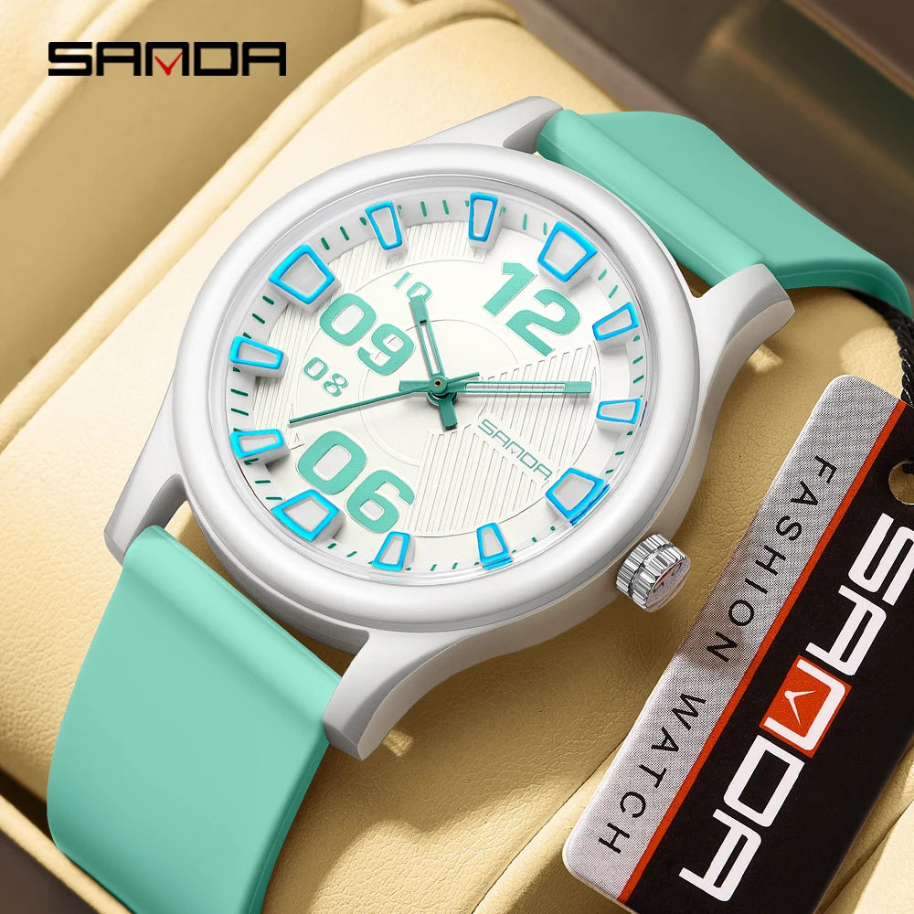 A white and teal fashion watch with a silver case and silicone strap resting on a light yellow leather surface.