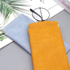 A bright orange premium PU leather eyewear storage bag next to a light blue one on a gray surface.