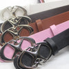 A close-up of a vintage gothic moon star buckle belt in black and silver on a pink leather strap.