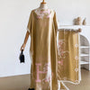Una caftán abaya beige con un delicado estampado de caballo rosa exhibido en un maniquí.