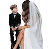 Una novia con vestido de novia blanco y velo de perlas con peine, junto a un novio.