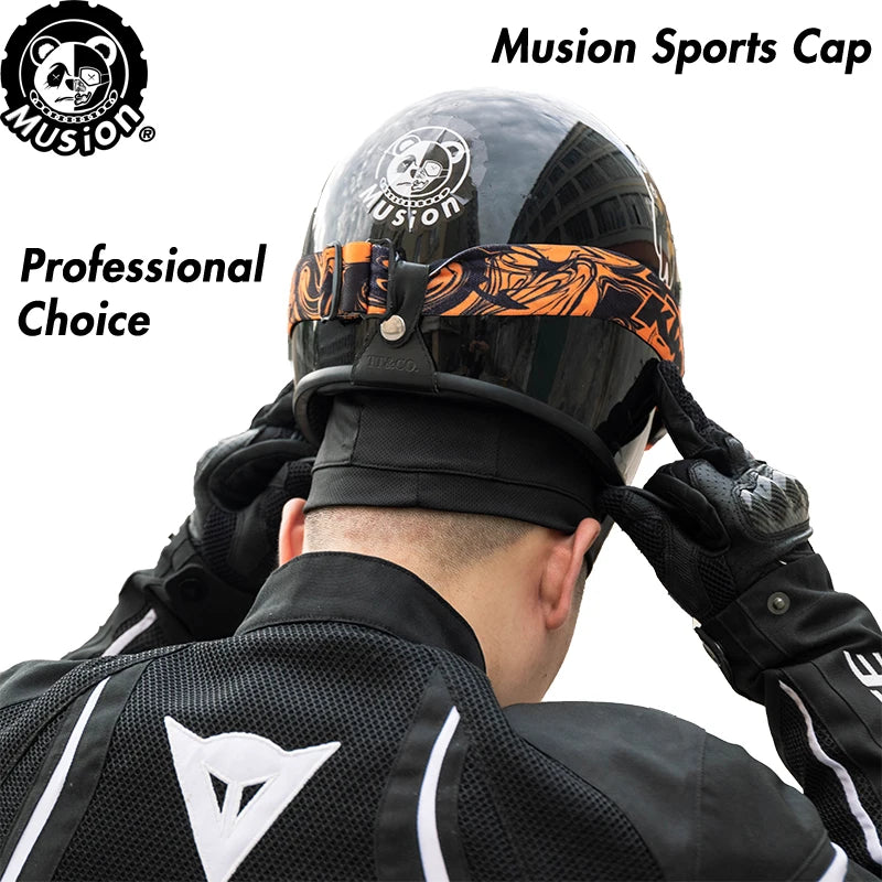 A close-up of a black and orange Musion Sports Cap being worn by a person, showing the front view of the helmet and cap.