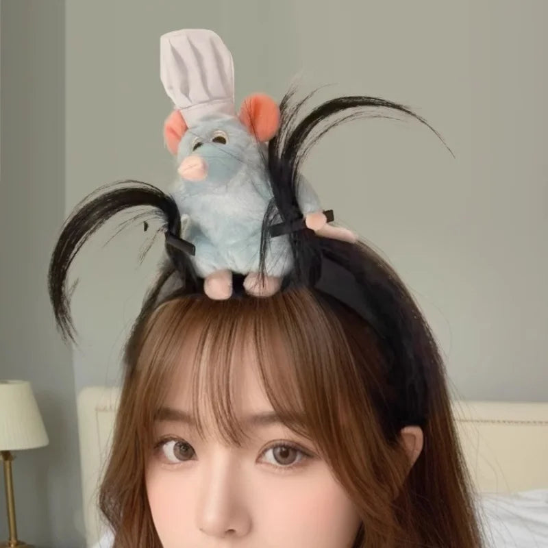 A woman wearing a cute plush mouse face hair accessory with black whiskers and ears.