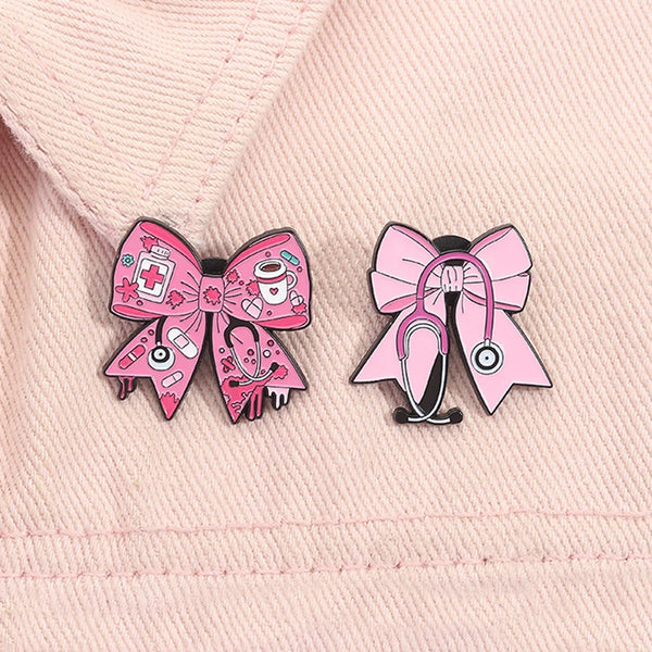 Pink enamel pin featuring a bow design with medical symbols and a stethoscope motif