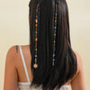 A woman shows off long black hair adorned with a bohemian sun moon tassel headdress