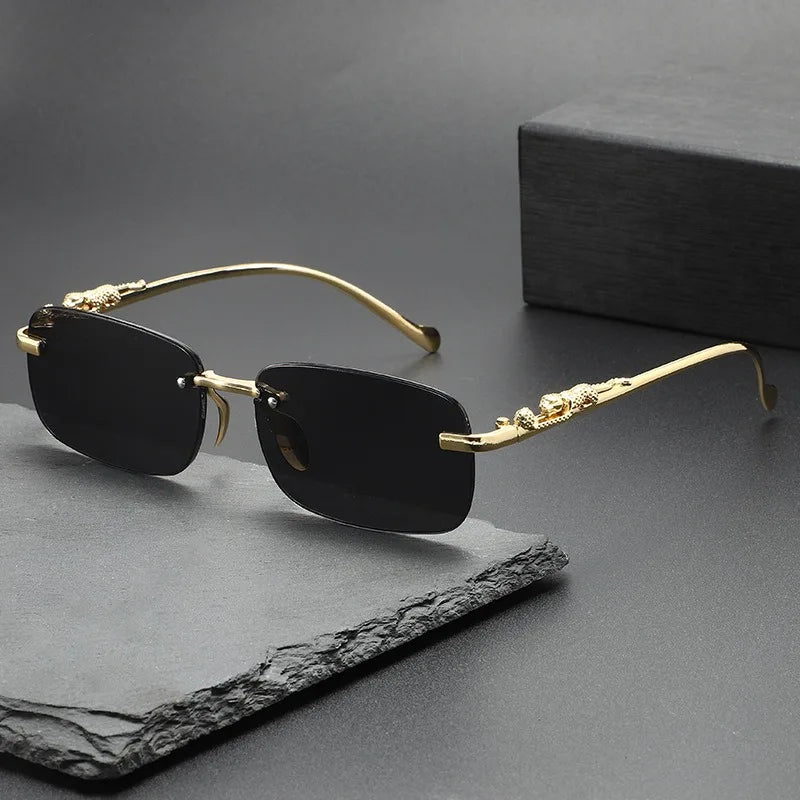 Gold-rimmed, black square sunglasses resting on a dark gray surface.