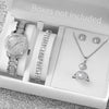 A white box contains a set of gold steel quartz watches, bracelets, and necklaces.