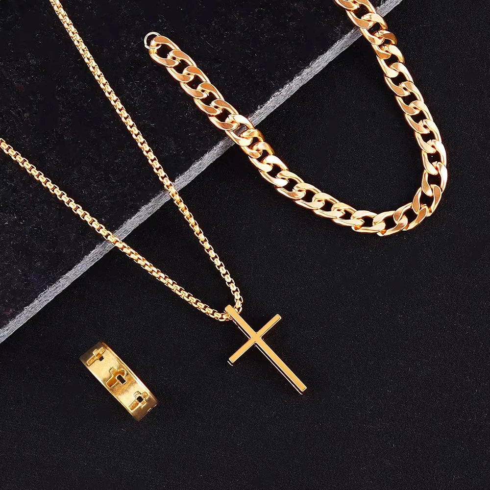 Un ensemble de chaînes en acier inoxydable de couleur or et un pendentif en forme de croix sur un fond sombre.