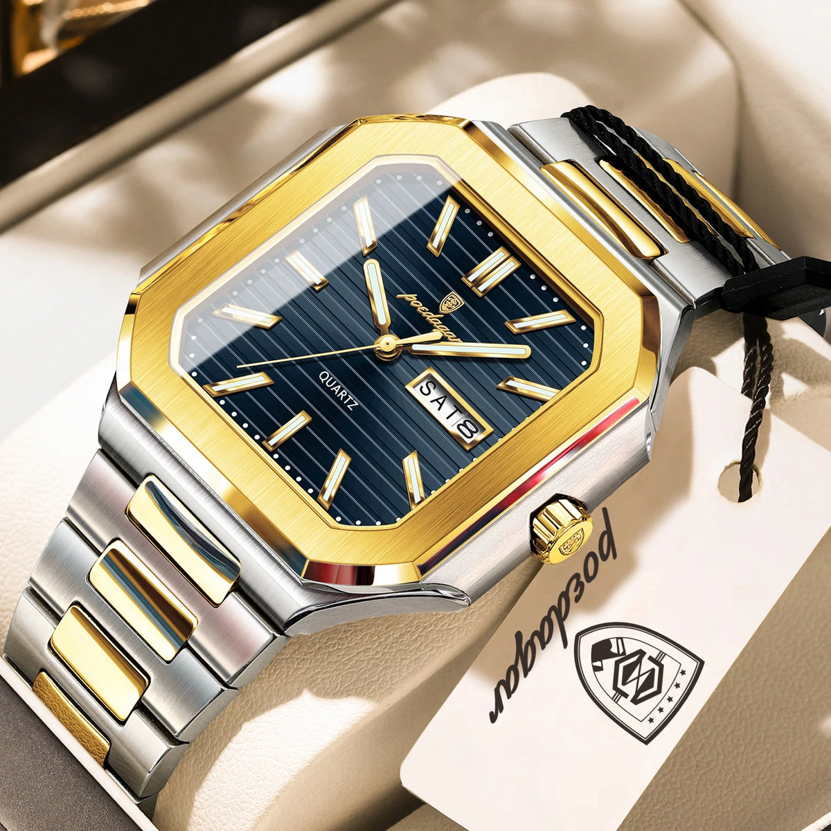 A close-up of a gold and silver stainless steel quartz watch with a dark blue dial and black strap resting on a light backgro
