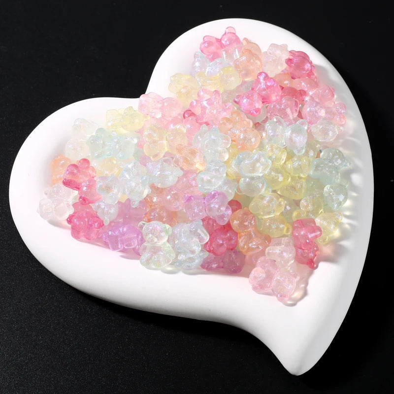 A pile of luminous glow-in-the-dark acrylic beads in shades of pink, yellow, and green resting on a white oval dish.
