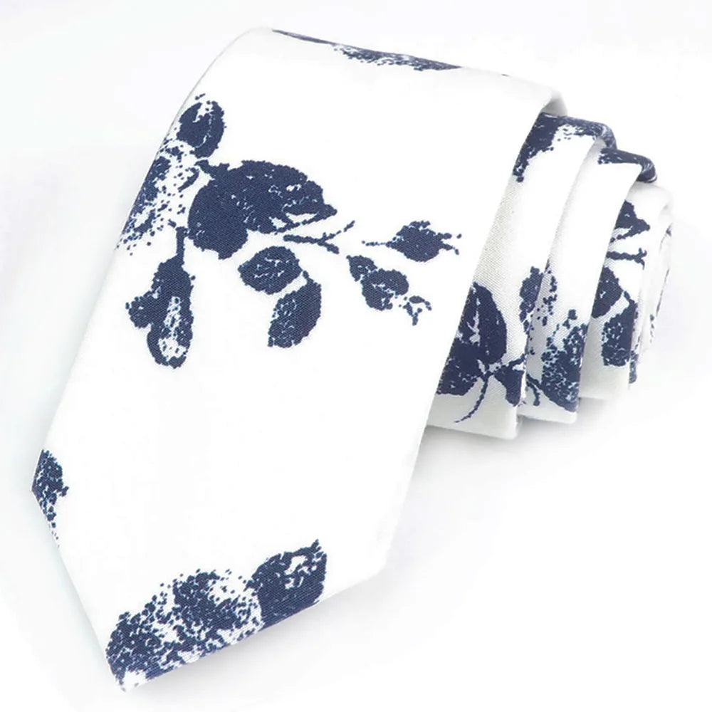 Une pile de cravates en coton à imprimé floral élégantes, blanches et bleu marine.