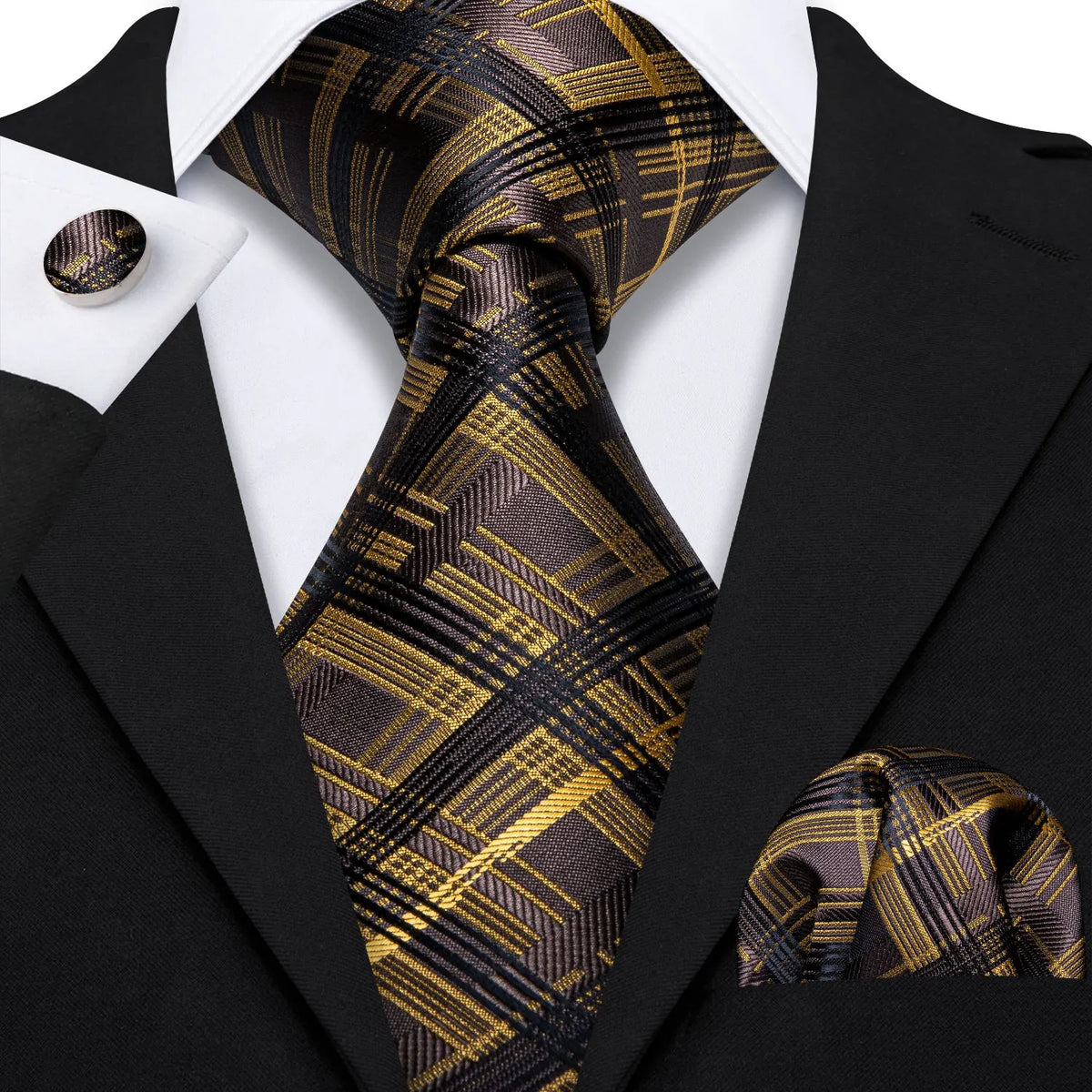 A close-up of a men's silk jacquard tie featuring a black and gold plaid pattern worn with a black suit jacket.