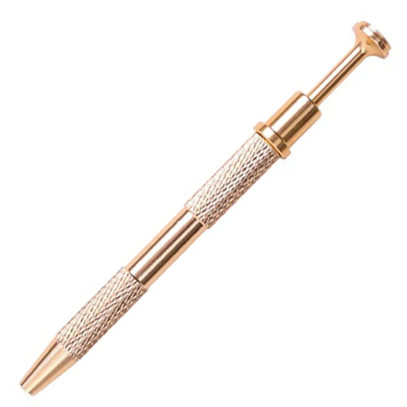 A close-up view of a gold-toned precision four-claw jewelry pick-up tool with textured handles.