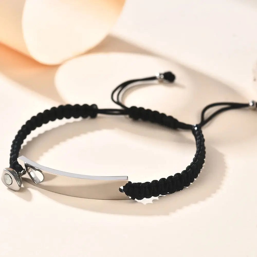 Maßgeschneidertes Edelstahl-Paararmband-Set mit schwarzem Band und silbernen Akzenten.