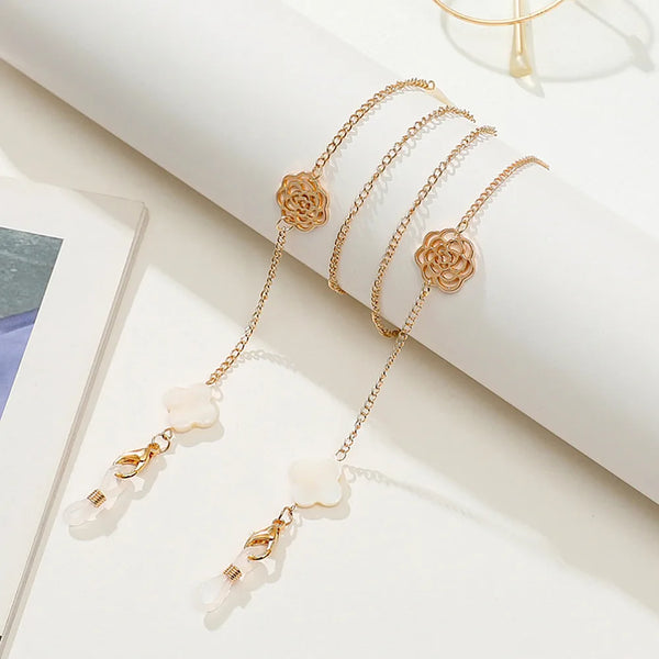 A delicate gold-toned chain necklace featuring rose and pearl charms displayed on a white background.