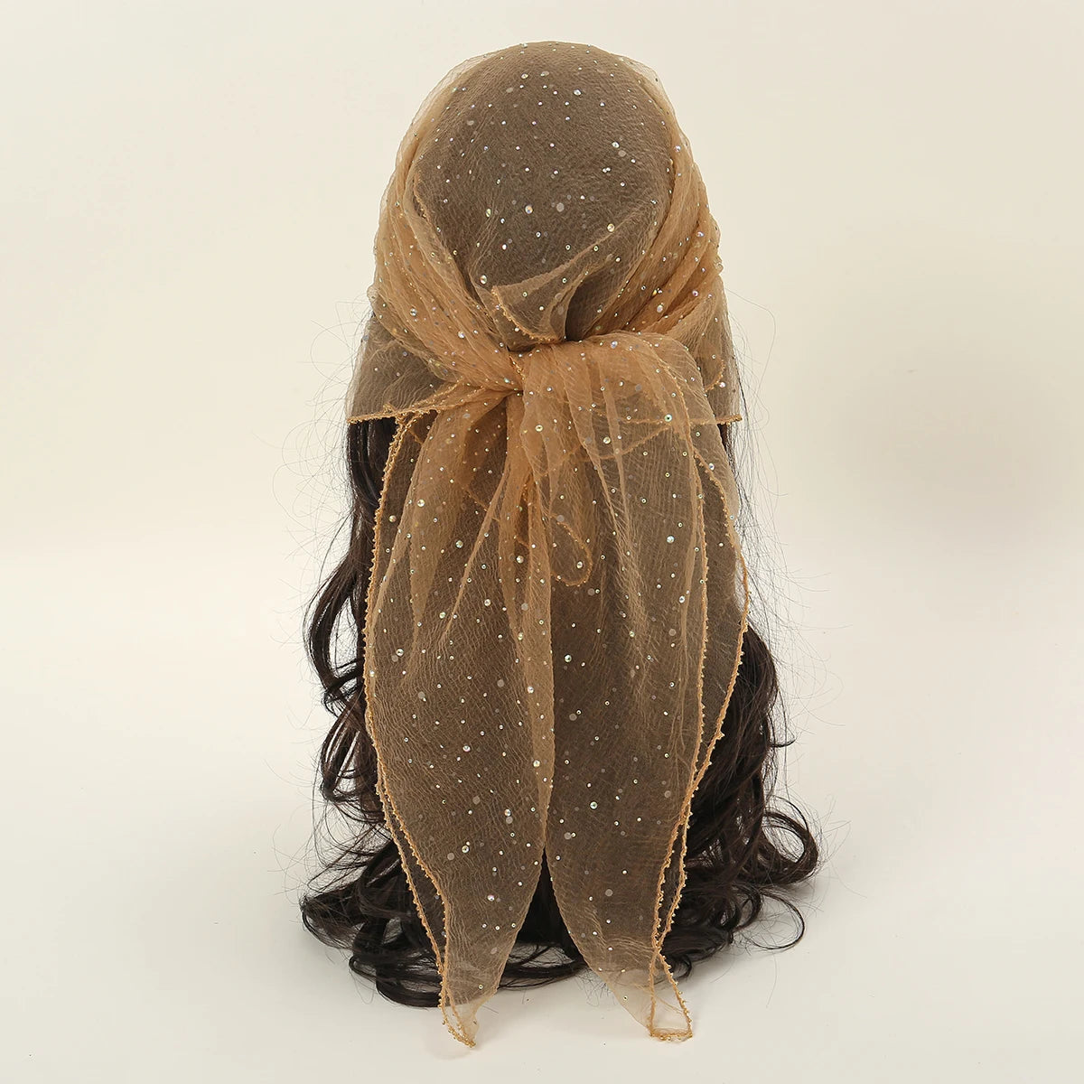 Durchscheinender, goldbrauner Mode-Hijab mit Glitzerdetails, drapiert über dunkles Haar.