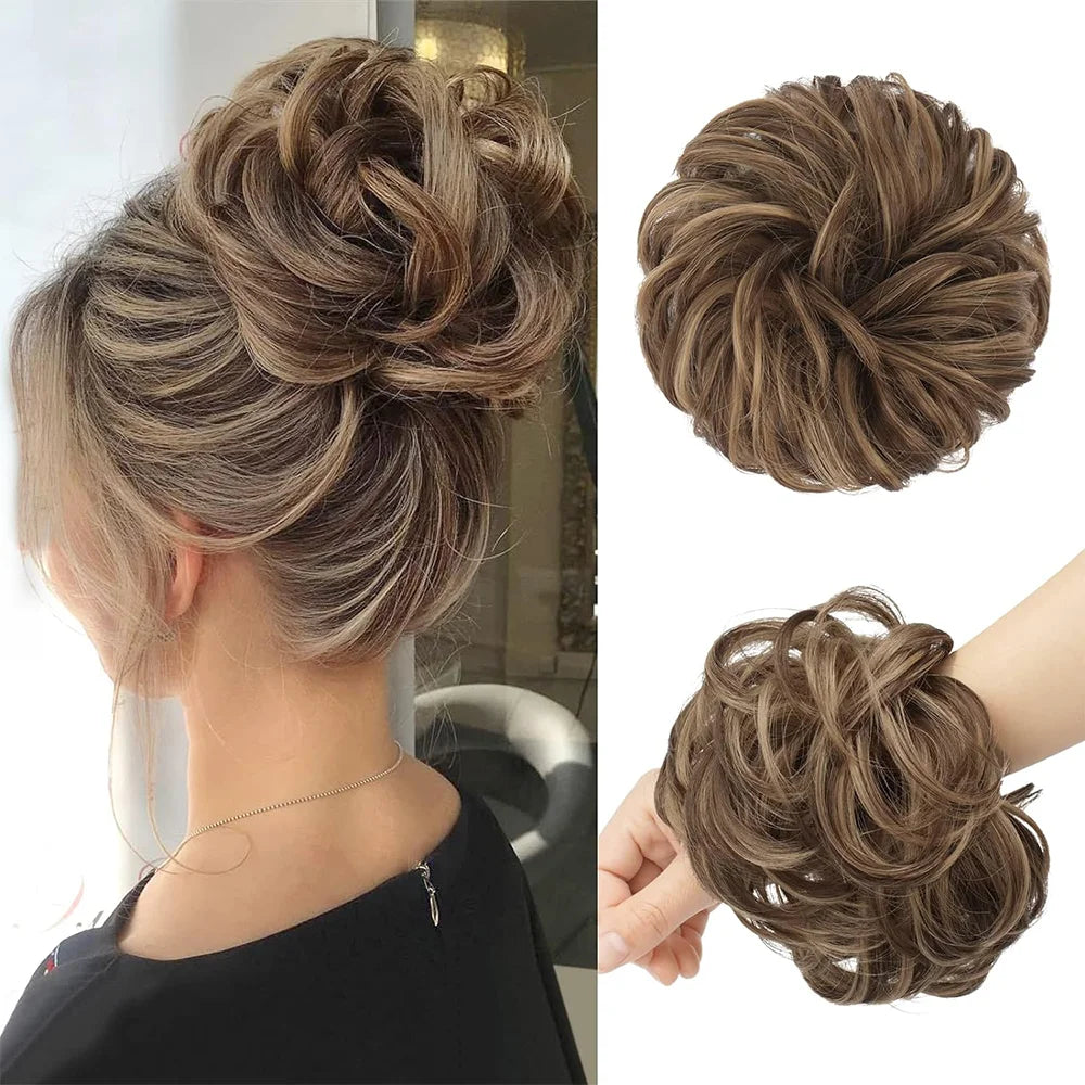 A close-up of a woman's hair styled in an elegant, textured updo with loose curls and a matching messy bun hair piece scrunch