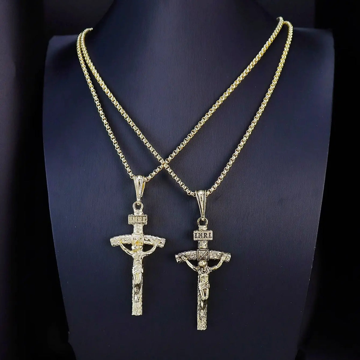 Goldvergoldetes Jesus-Kreuz-Anhänger mit verzierten Kette auf schwarzem Samt.