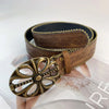 A vintage brown PU leather boho western belt with a decorative gold buckle displayed on a clear surface.