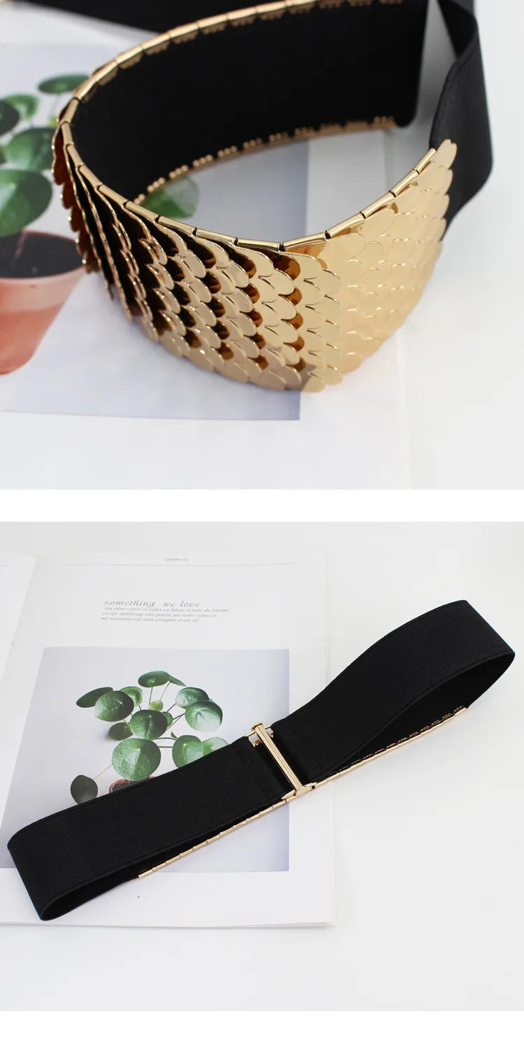 Ceinture élastique large texturée en or portée à la taille d'une femme sur fond blanc.