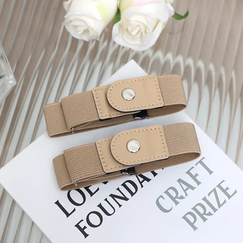 A beige elastic casual belt with a round silver buckle is displayed on a white card.